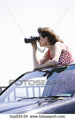 Picture - Woman looking through binoculars. Fotosearch