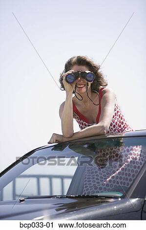 Stock Image - Woman looking through binoculars. Fotosearch