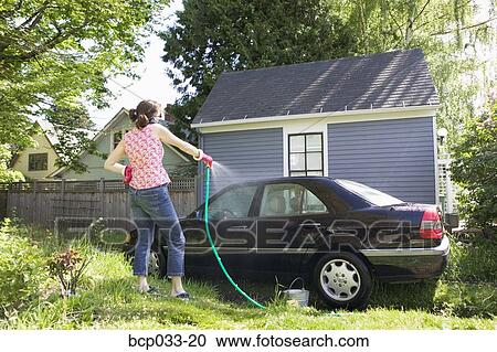 Woman on cordless phone washing car View Large Photo Image Stock Image - Woman on cordless phone washing car. Fotosearch