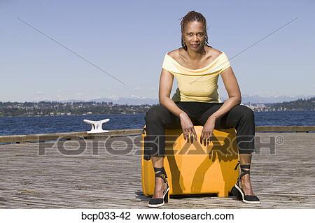 Woman outdoors sitting on suitcase View Large Photo Image Stock Image - Woman outdoors sitting on suitcase. Fotosearch