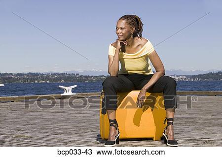 Woman outdoors sitting on suitcase View Large Photo Image Stock Image - Woman outdoors sitting on suitcase. Fotosearch