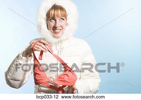 Woman wearing parka holding bikini top View Large Photo Image Stock Image - Woman wearing parka holding bikini top. Fotosearch