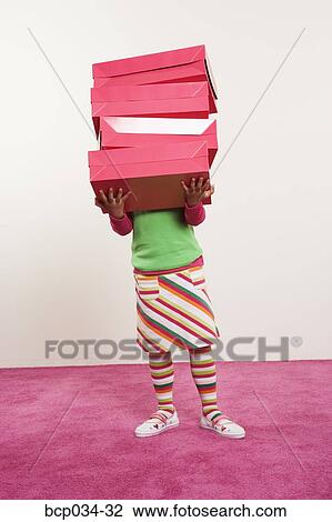 Girl holding many boxes in front of face View Large Photo Image Stock Image - Girl holding many boxes in front of face. Fotosearch