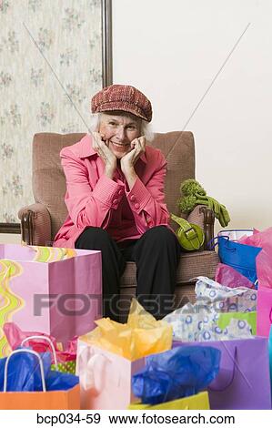 Stock Photo - Happy woman surrounded by shopping bags. Fotosearch