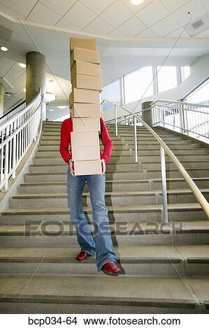 Woman carrying boxes downstairs View Large Photo Image Picture - Woman carrying boxes downstairs. Fotosearch