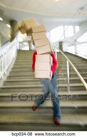 Woman carrying boxes downstairs View Large Photo Image Stock Photo - Woman carrying boxes downstairs. Fotosearch