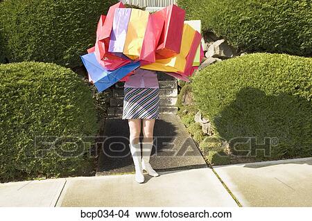 Woman carrying many shopping bags View Large Photo Image Picture - Woman carrying many shopping bags. Fotosearch