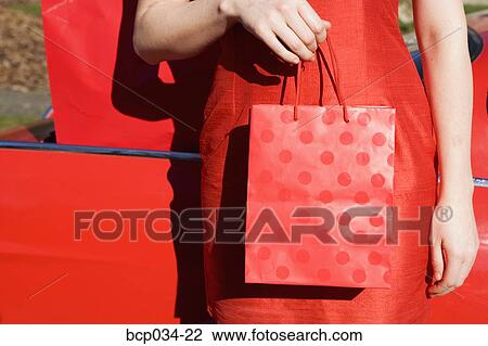 Woman holding shopping bag, close-up View Large Photo Image Stock Image - Woman holding shopping bag, close-up. Fotosearch
