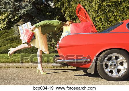 Woman looking in trunk of car View Large Photo Image Stock Photo - Woman looking in trunk of car. Fotosearch