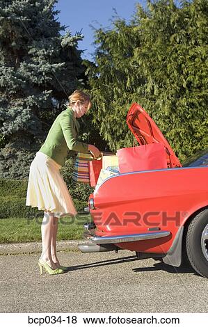 Woman removing shopping bags from car View Large Photo Image Stock Photo - Woman removing shopping bags from car. Fotosearch