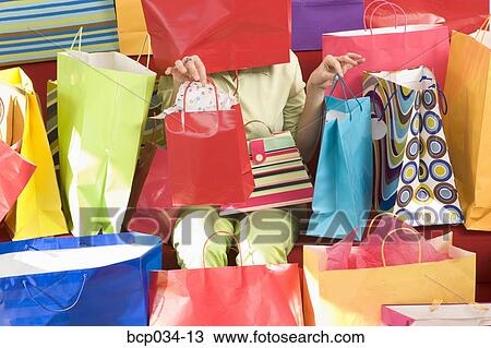 Stock Image - Woman surrounded by shopping bags. Fotosearch