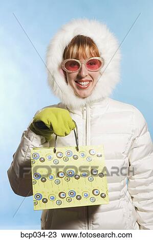 Woman wearing parka holding shopping bag View Large Photo Image Stock Image - Woman wearing parka holding shopping bag. Fotosearch