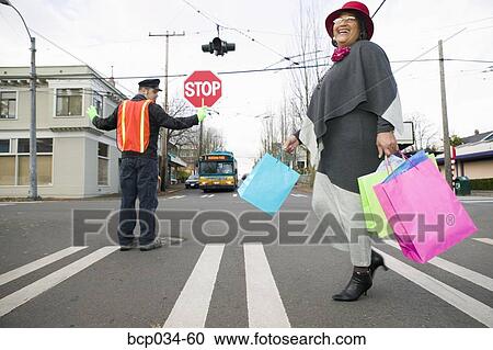Woman with shopping bags crossing street View Large Photo Image Stock Image - Woman with shopping bags crossing street. Fotosearch