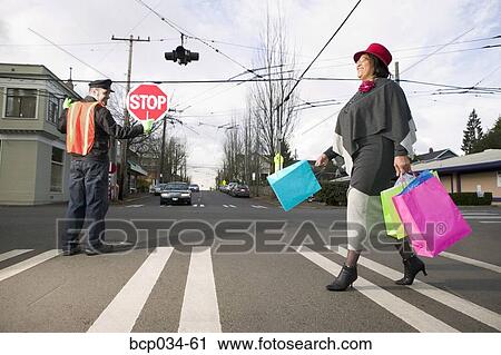 Woman with shopping bags crossing street View Large Photo Image Stock Image - Woman with shopping bags crossing street. Fotosearch