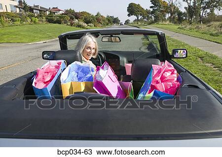 Woman with shopping bags in convertible View Large Photo Image Stock Image - Woman with shopping bags in convertible. Fotosearch
