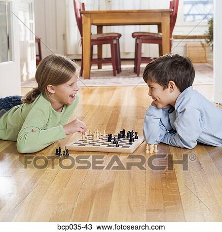 Boy and girl playing chess View Large Photo Image Stock Image - Boy and girl playing chess. Fotosearch