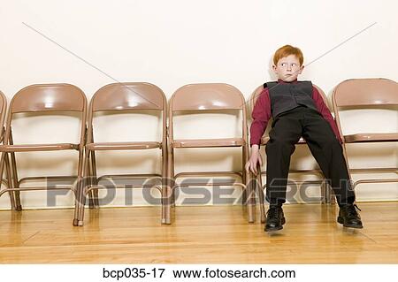 Boy slouching in folding chair View Large Photo Image Stock Photo - Boy slouching in folding chair. Fotosearch