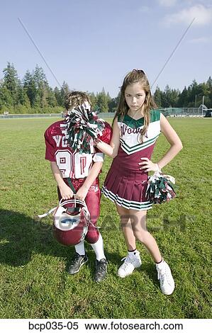 Stock Photography - Cheerleader posing with football player . Fotosearch