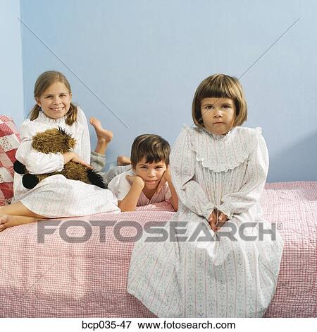Children sitting on bed in pajamas View Large Photo Image Stock Photo - Children sitting on bed in pajamas. Fotosearch