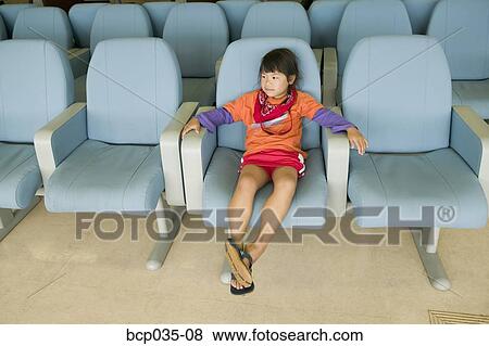 Stock Photo - Girl alone sitting in chair. Fotosearch