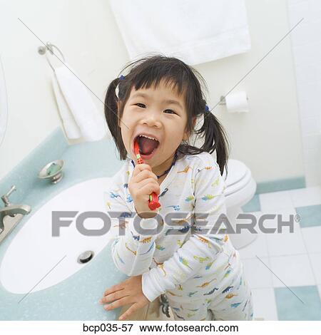 Girl wearing pajamas brushing teeth View Large Photo Image Stock Photo - Girl wearing pajamas brushing teeth. Fotosearch