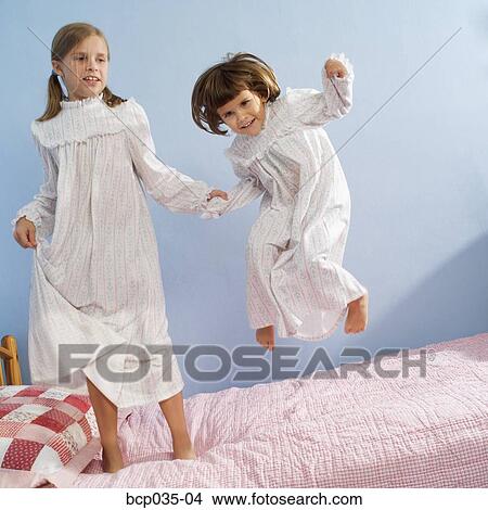 Girls jumping on bed View Large Photo Image Picture - Girls jumping on bed. Fotosearch