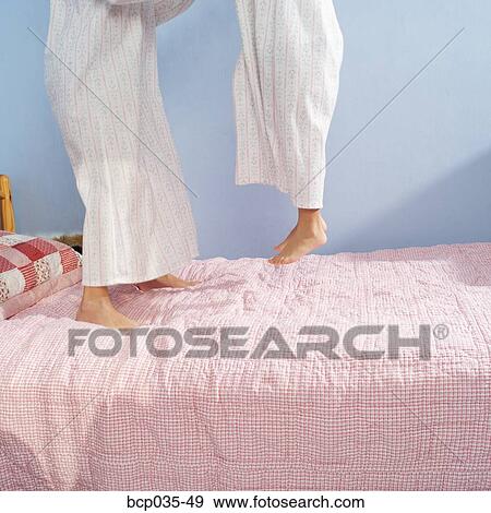 Stock Photo - Girls jumping on bed. Fotosearch