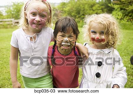 Stock Image - Girls wearing face paint. Fotosearch
