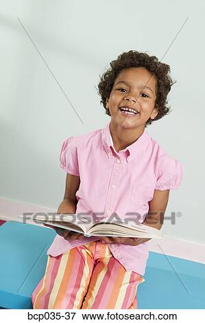Smiling girl holding book View Large Photo Image Stock Photo - Smiling girl holding book. Fotosearch