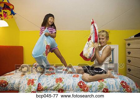 Stock Photo - Boy and girl having pillow fight. Fotosearch