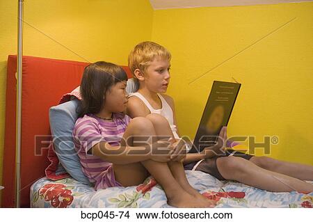 Picture - Brother reading to his little sister. Fotosearch