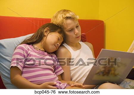 Brother reading to his little sister View Large Photo Image Stock Photograph - Brother reading to his little sister. Fotosearch
