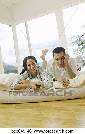Couple watching television at home View Large Photo Image Stock Photograph - Couple watching television at home. Fotosearch