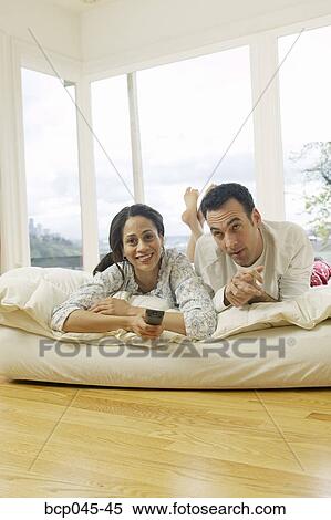 Stock Photography - Couple watching television at home. Fotosearch