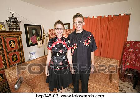 Stock Image - Couple wearing Asian clothing at home. Fotosearch