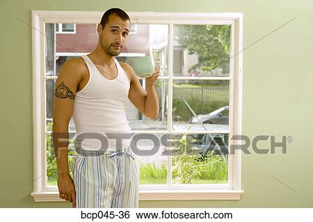 Man in pajamas holding coffee cup View Large Photo Image Stock Photograph - Man in pajamas holding coffee cup. Fotosearch