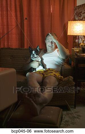 Man in underwear watching TV with dog View Large Photo Image Stock Photograph - Man in underwear watching TV with dog. Fotosearch