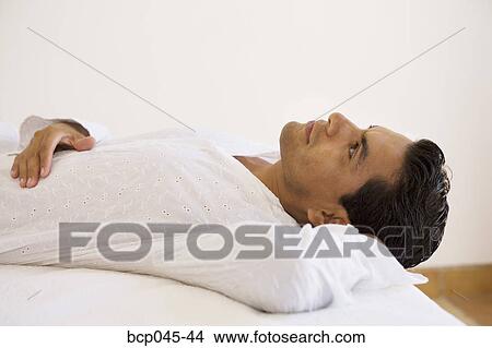 Man lying down and thinking View Large Photo Image Picture - Man lying down and thinking. Fotosearch