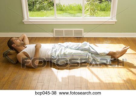 Man lying on floor at home View Large Photo Image Stock Photo - Man lying on floor at home. Fotosearch