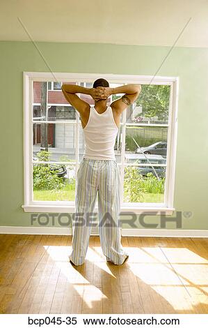 Man standing in front of window in pajamas View Large Photo Image Stock Photography - Man standing in front of window in pajamas. Fotosearch