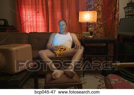Stock Photo - Man watching television in underwear. Fotosearch