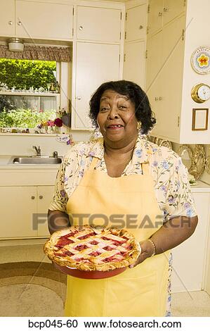 Stock Image - Portrait of woman holding homemade pie. Fotosearch