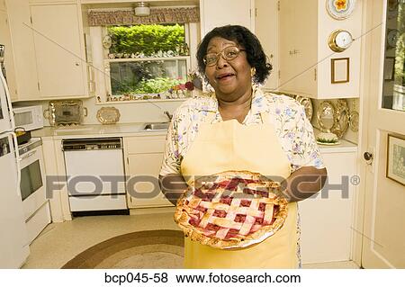 Stock Photo - Portrait of woman holding homemade pie. Fotosearch