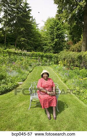 Portrait of woman sitting in park View Large Photo Image Stock Photo - Portrait of woman sitting in park. Fotosearch