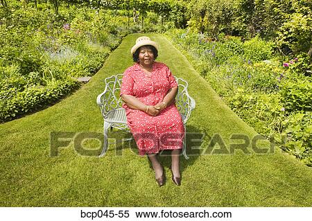 Stock Photography - Portrait of woman sitting in park. Fotosearch