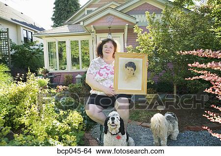 Woman holding portrait of herself as a girl View Large Photo Image Picture - Woman holding portrait of herself as a girl. Fotosearch