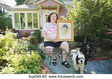 Woman holding portrait of herself as a girl View Large Photo Image Stock Image - Woman holding portrait of herself as a girl. Fotosearch