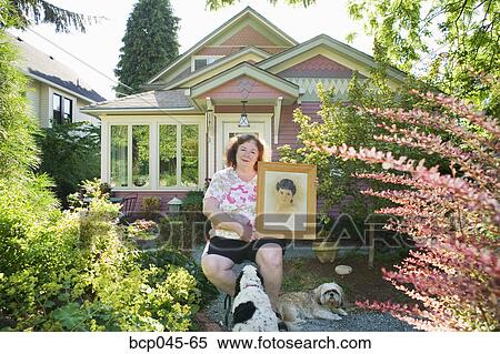 Woman holding portrait of herself as a girl View Large Photo Image Stock Photography - Woman holding portrait of herself as a girl. Fotosearch