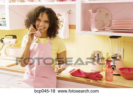 Woman talking on phone in kitchen View Large Photo Image Stock Photo - Woman talking on phone in kitchen. Fotosearch