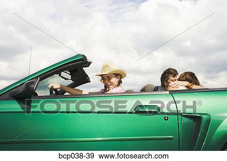 Girl pretending to drive while parents kiss View Large Photo Image Stock Photo - Girl pretending to drive while parents kiss. Fotosearch